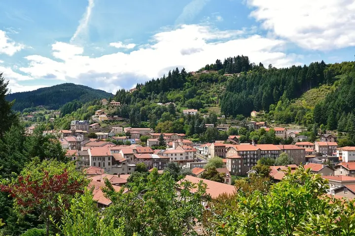 Les toits du Cheylard entourés de collines boisées